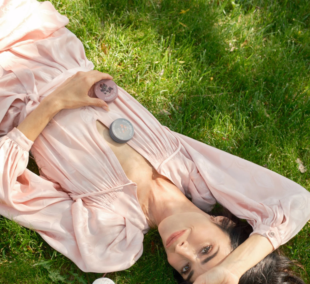 Abigail Spencer lying in the grass beside Norse Organics jars